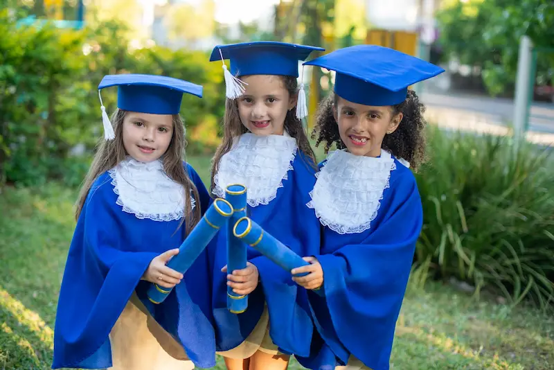 Meninas com toga em formatura infantil canudo